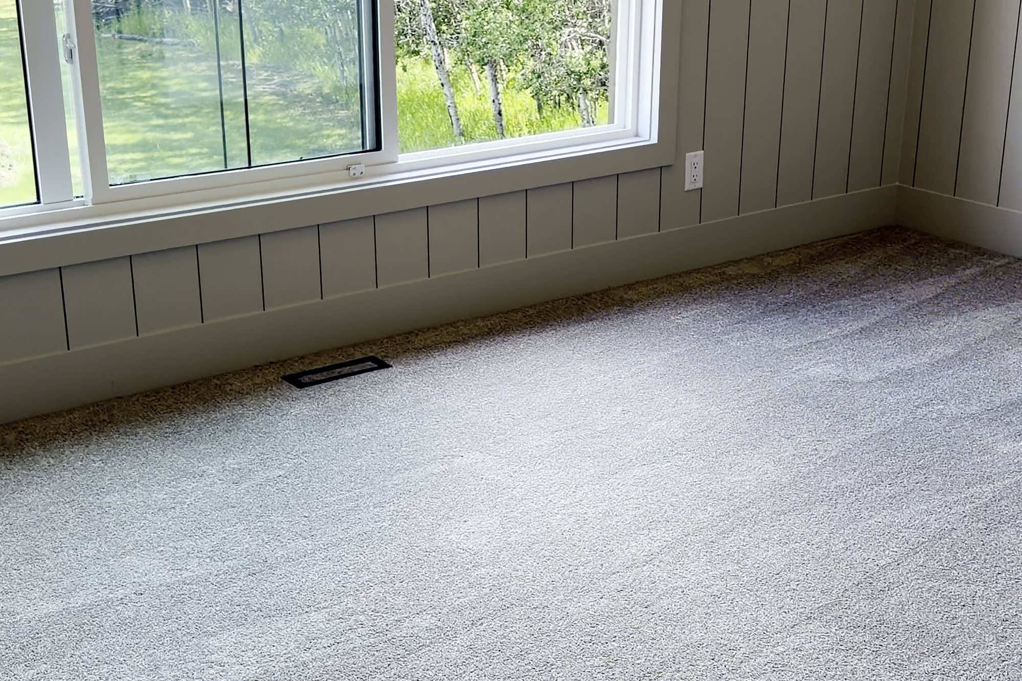 Bedroom with clean windows, panelled walls and freshly vacuumed carpet