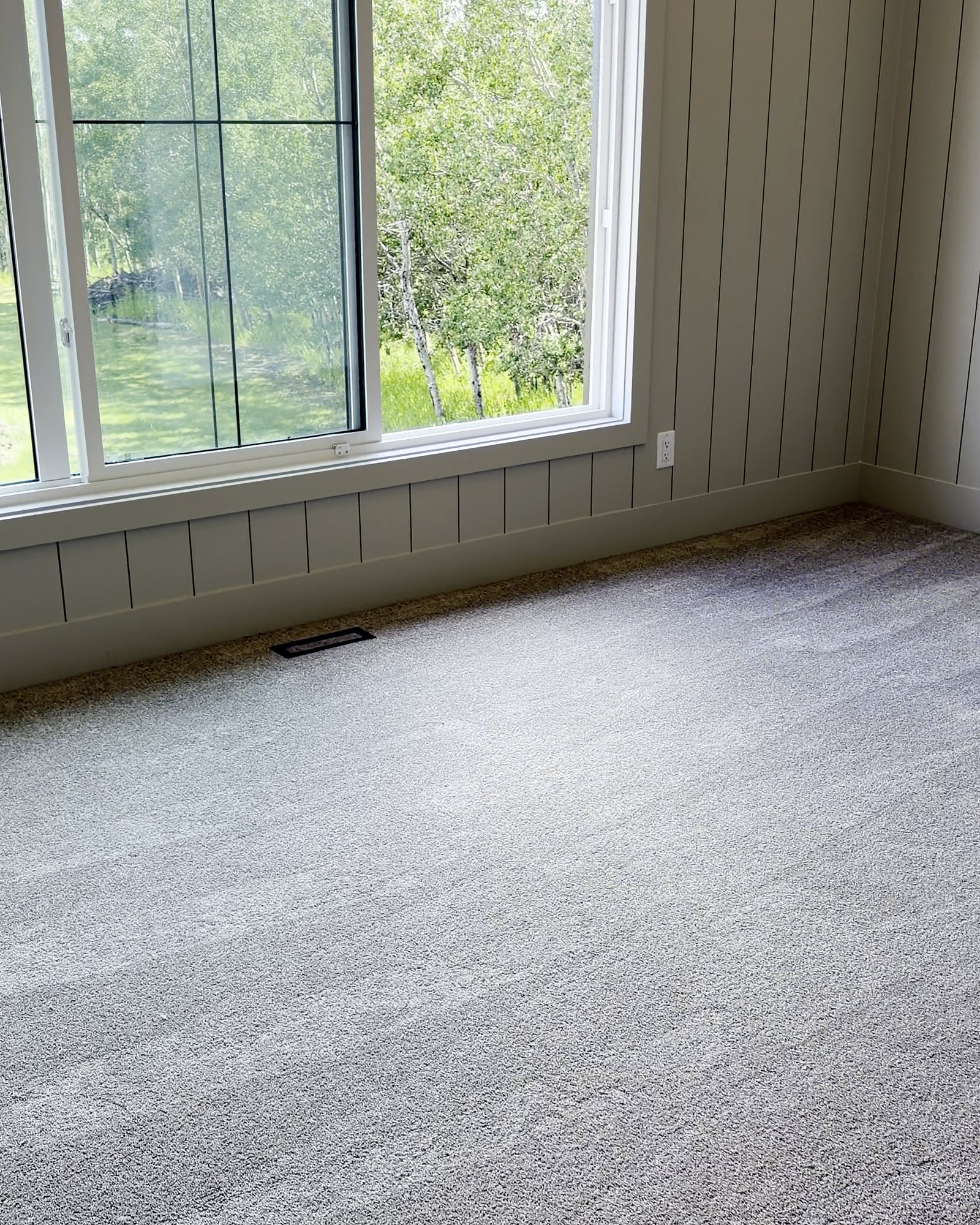 Bedroom with clean windows, panelled walls and freshly vacuumed carpet