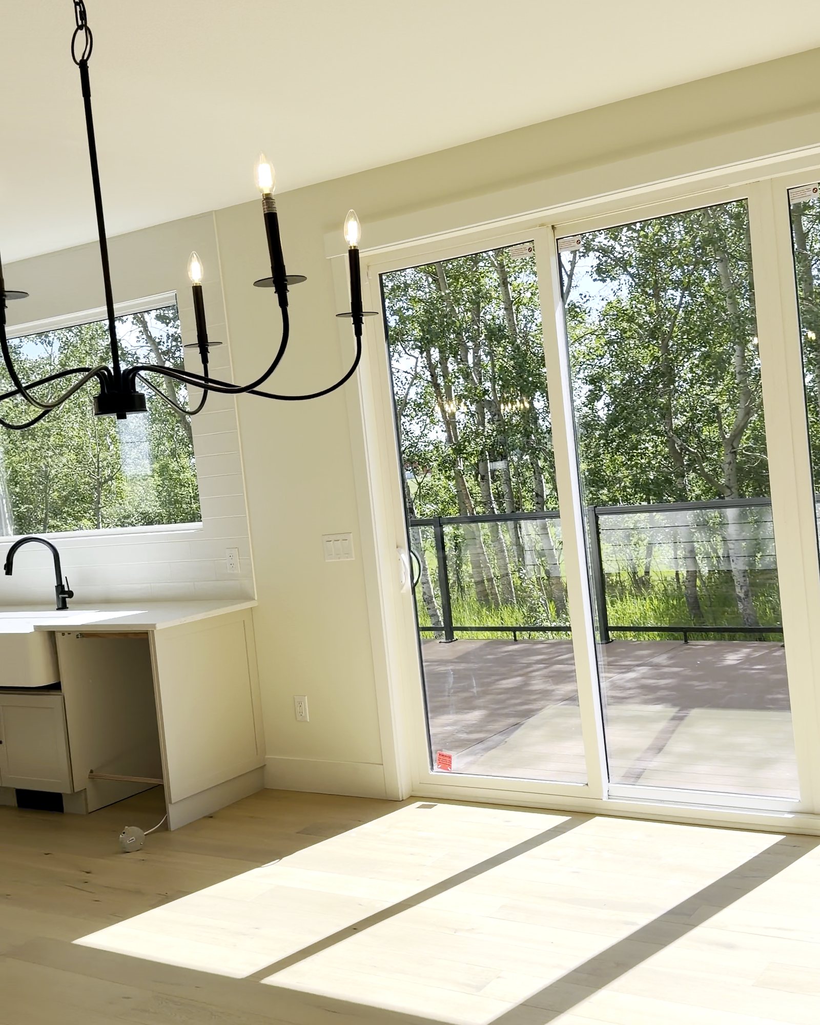 A bright new dining area after cleaning: clean plank floor, patio door and windows