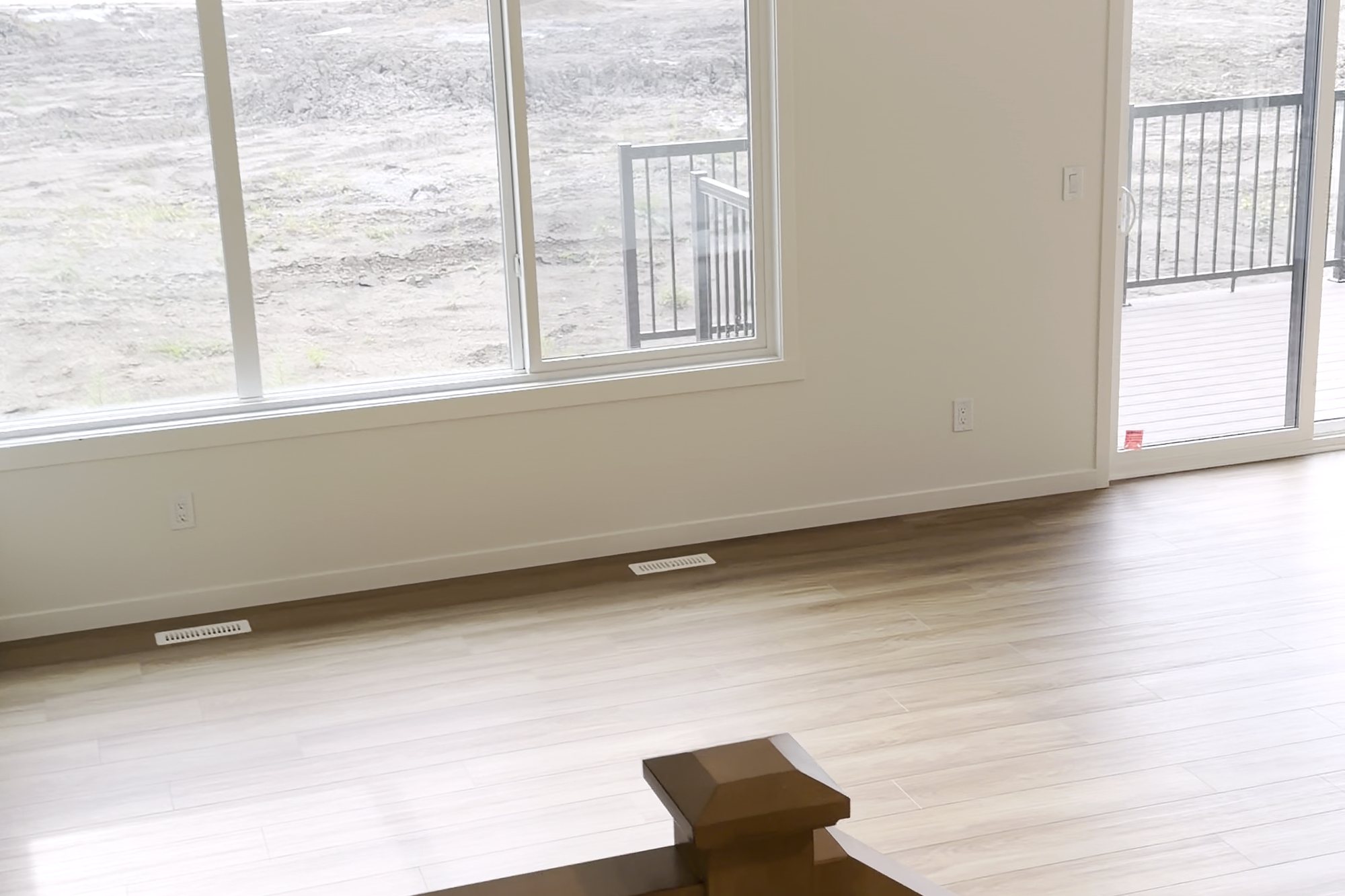 Open living room seen from the stair landing, with clean floors and windows