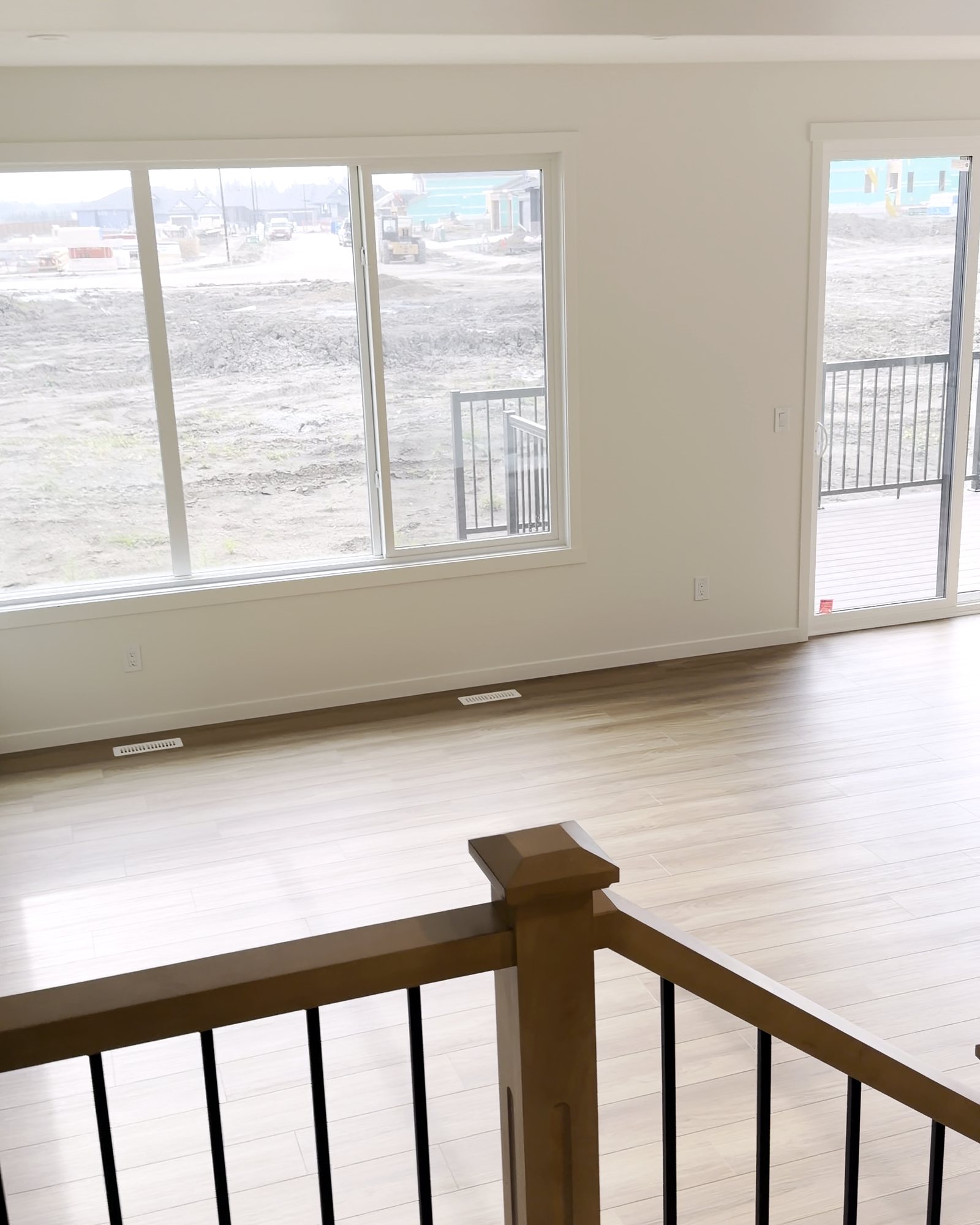 Open living room seen from the stair landing, with clean floors and windows